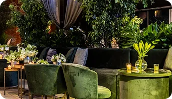 A green velvet lounge with candlelight and plants