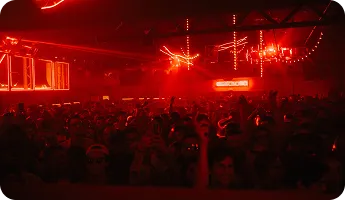 A packed crowd under red nightclub lights