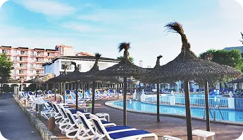 Poolside loungers under straw umbrellas